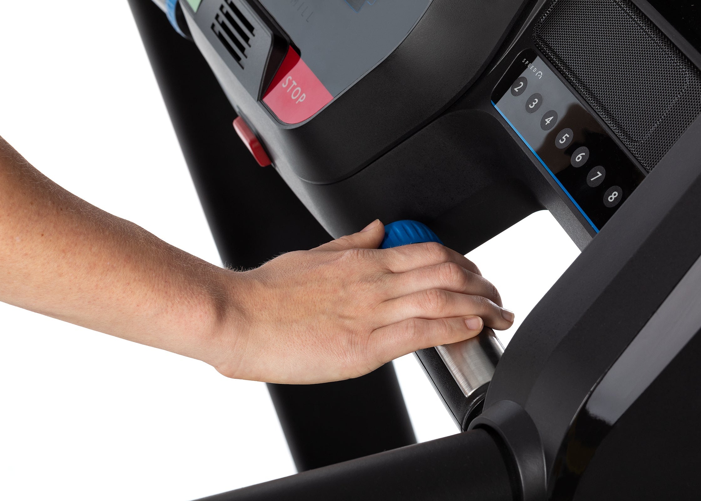 Person adjusting a treadmill with a close-up of the hand and control panel.